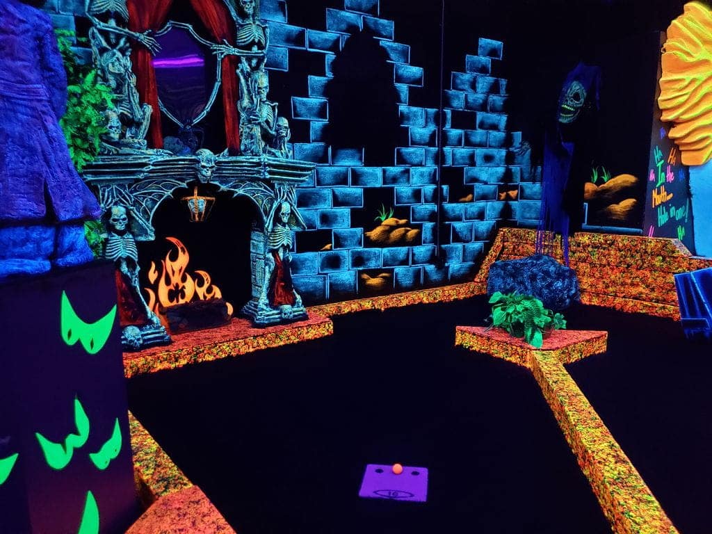 Why Parents Love Us For Birthday Parties 1 Neon decorations at a monster mini golf location.